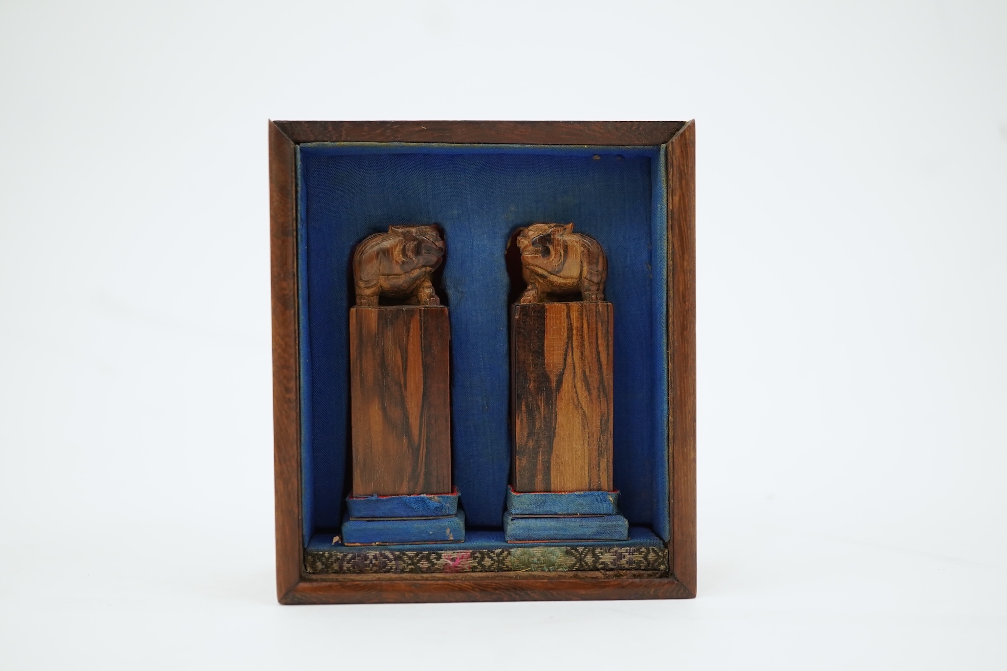 A cased pair of Chinese hardwood ‘lion-dog’ seals, early 20th century
